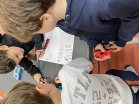 Ce visuel montre 3 élèves entrain de poser une addition sur une feuille.